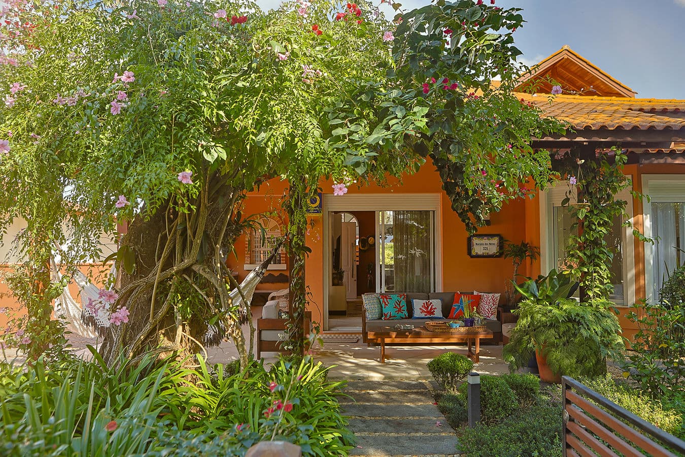 Entrada com lounge e jardim tropical exuberante