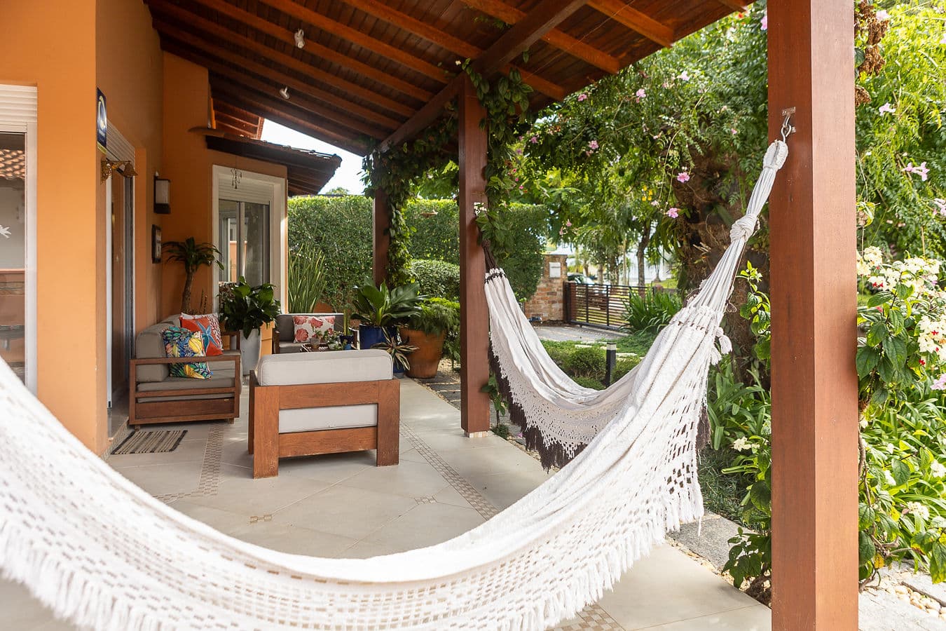 Varanda com rede e lounge à sombra do jardim