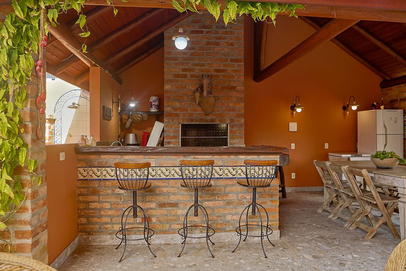 Bar da área gourmet com bancada de azulejos e churrasqueira