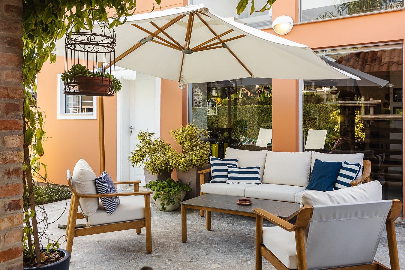Lounge externo com sofás de madeira e guarda-sol