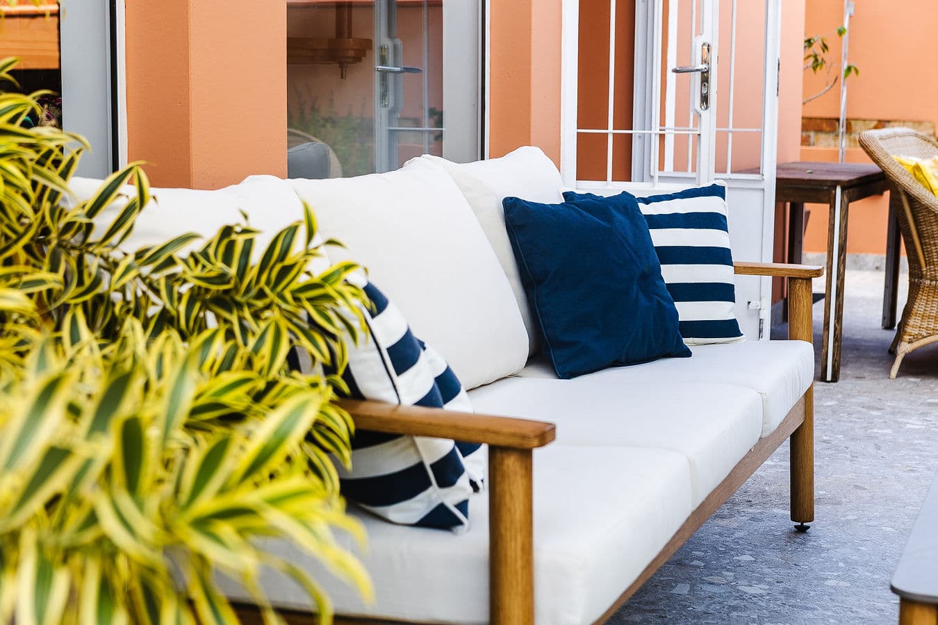 Detalhe do sofá com almofadas listradas azul e branco