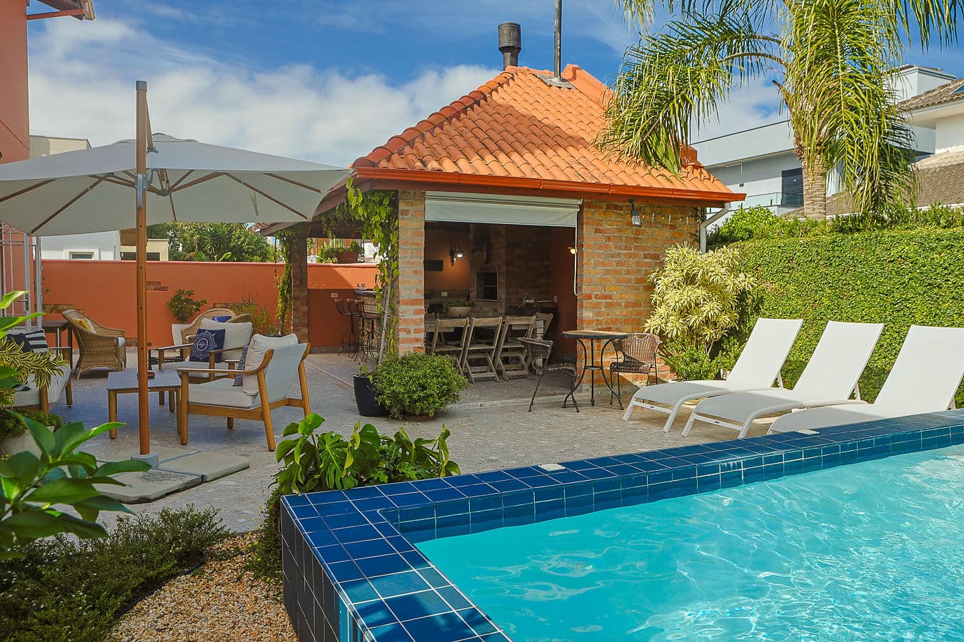 Piscina, espreguiçadeiras e pavilhão gourmet com telhado de barro