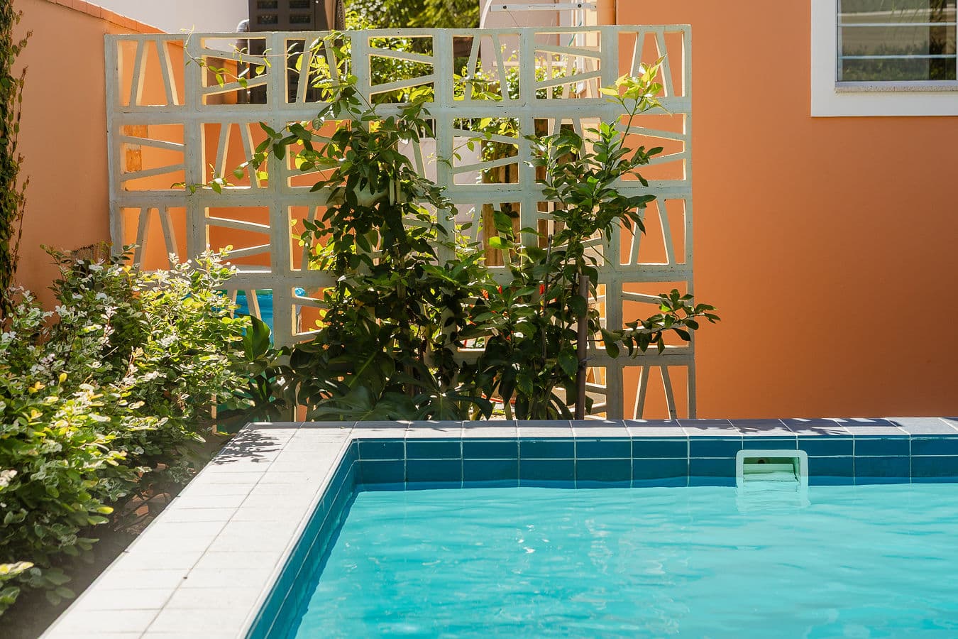 Recanto da piscina com painel vazado e jardim