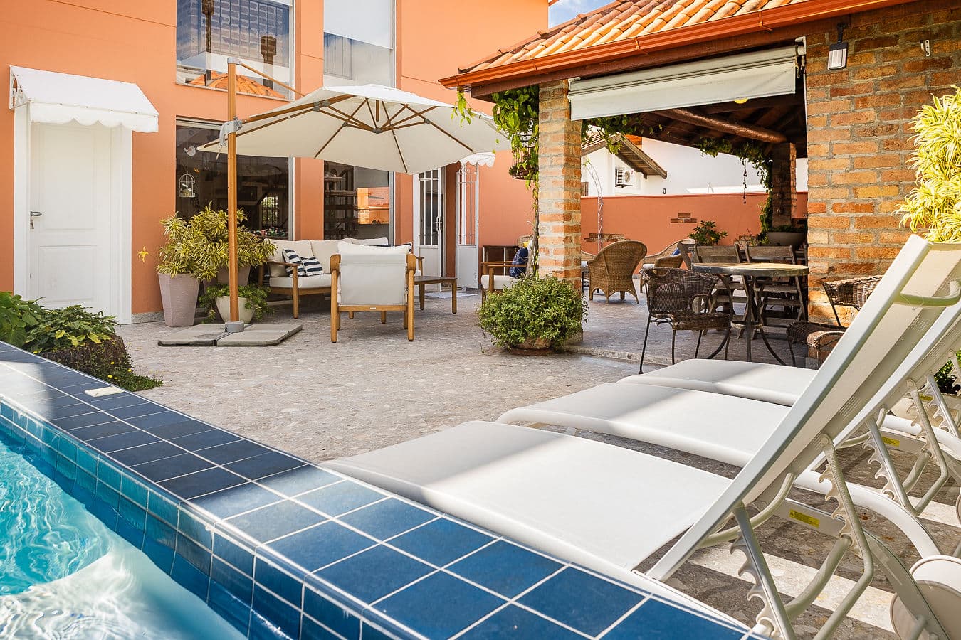Borda da piscina com lounge e área gourmet