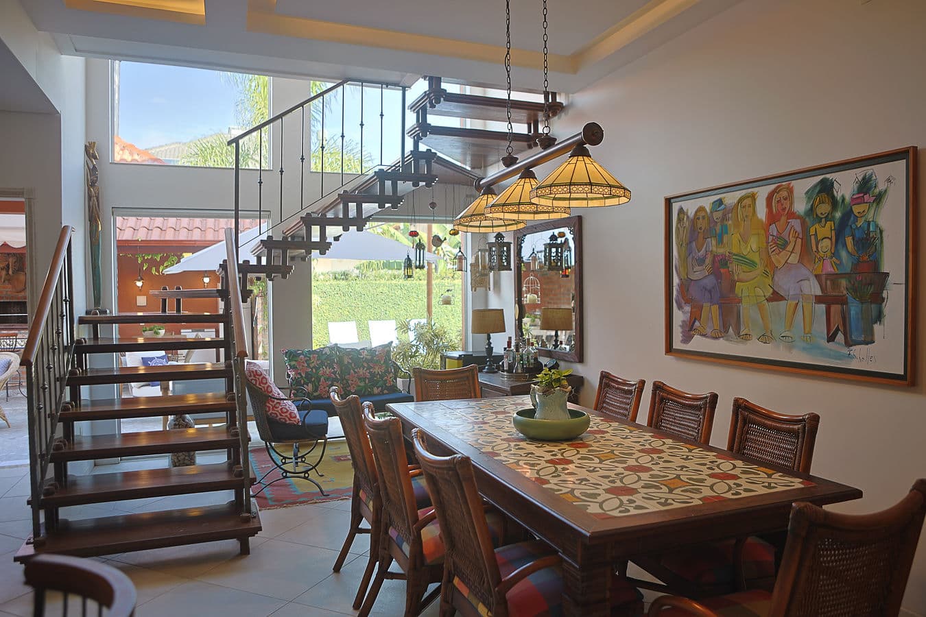 Sala de jantar com escada de madeira, mezanino e arte autoral