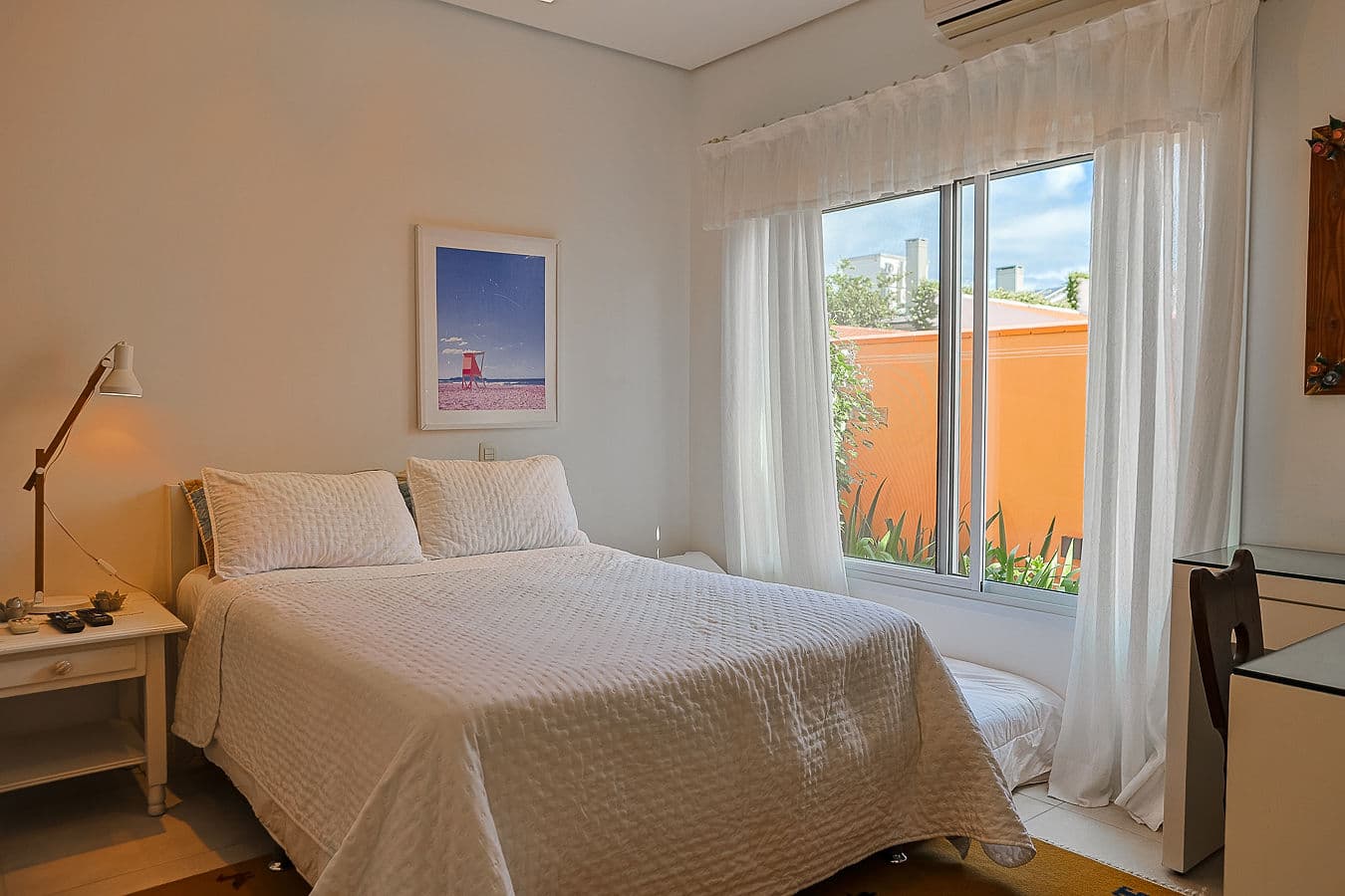 Quarto amplo com cama de casal e janela para o jardim