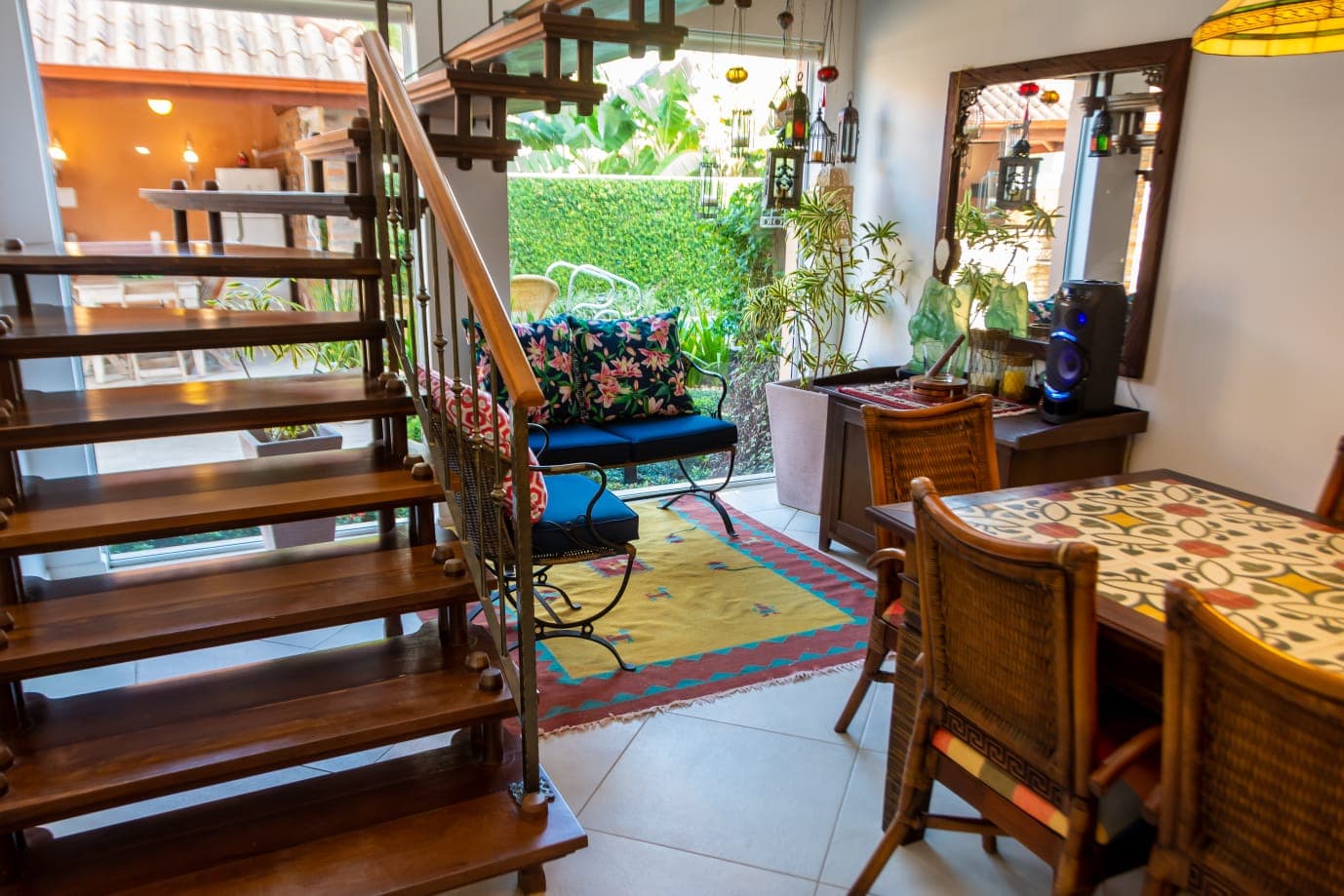 Escada de madeira, sala de jantar e estar com saída para o jardim